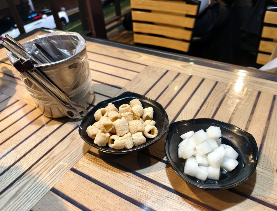隨桌送上的開胃通心粉餅乾與解膩糖醋醃蘿蔔,附有方便進食的小鐵夾與專用垃圾桶