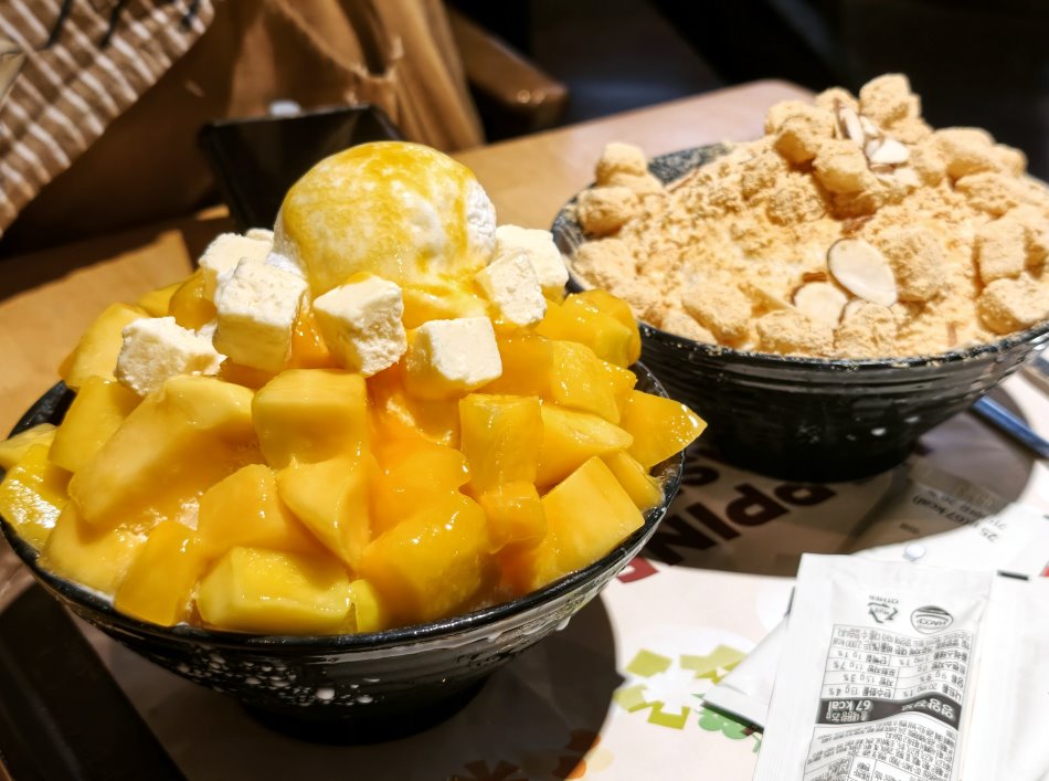 鋪滿大塊鮮黃芒果切丁、起司蛋糕丁與優格冰淇淋的芒果起司雪冰特寫