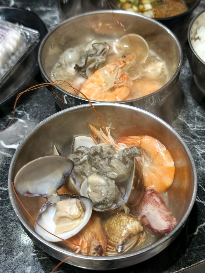 裝滿煮熟蛤蜊鮮蚵與白蝦的精緻小碗