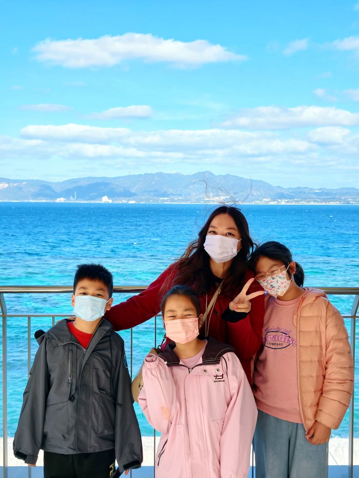 全家於許田休息站觀景天橋合影與名護灣海景
