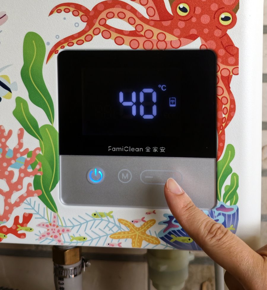 手指輕觸全家安熱水器液晶螢幕調溫，具備大字體顯示與面板防誤觸鎖定