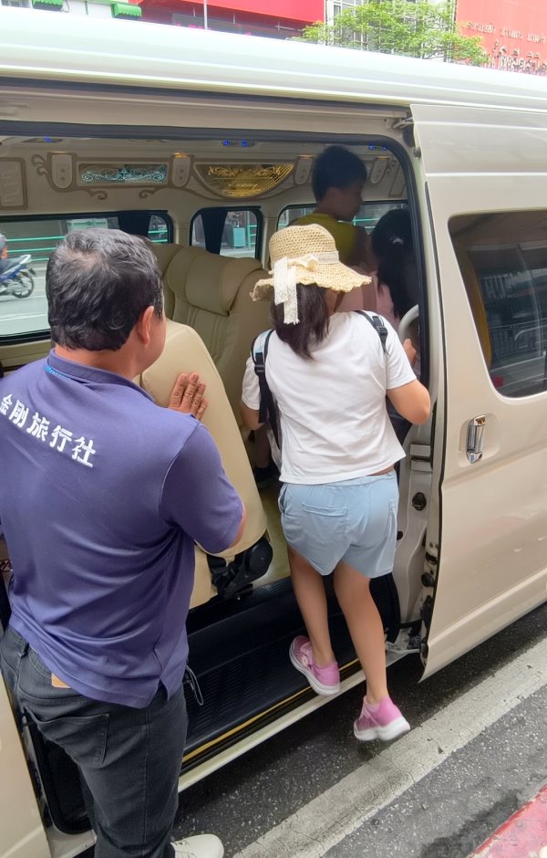金剛旅行社專業司機細心攙扶小朋友上車
