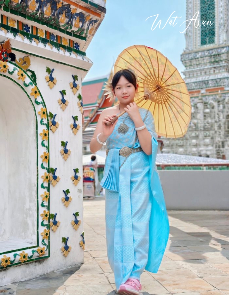 大女兒著水藍泰服手持油紙傘漫步