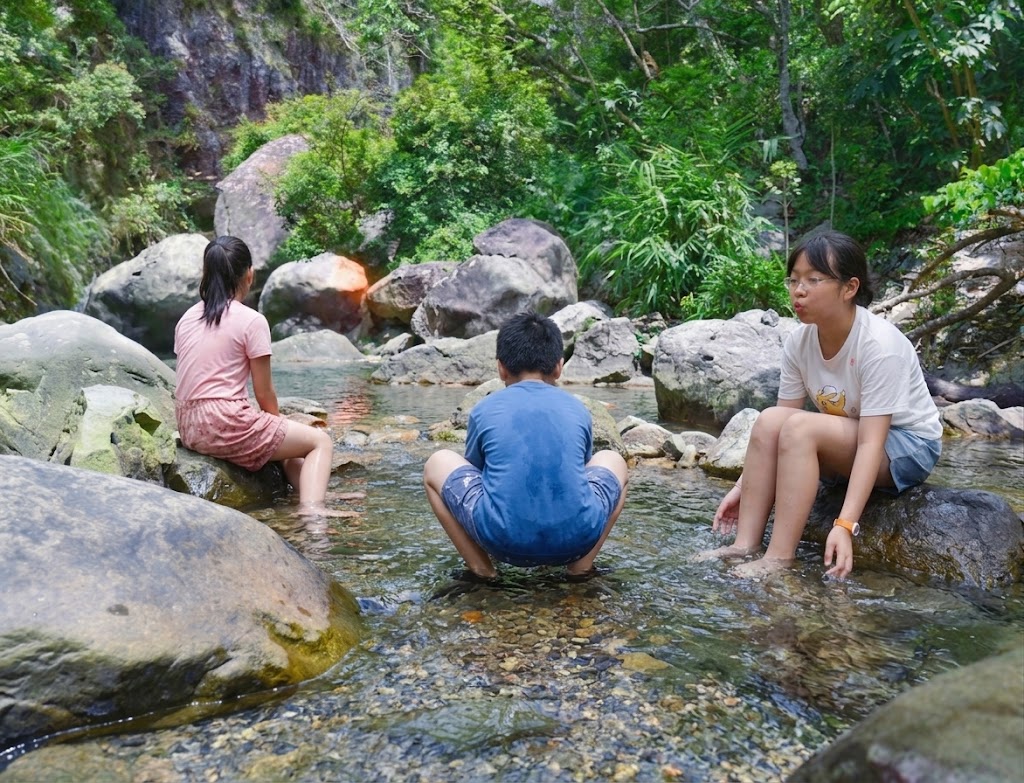 三寶坐在溪石上享受猴洞坑天然清涼溪水泡腳