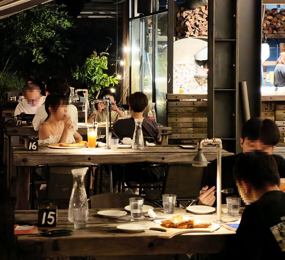 空ㄟ農場戶外露台顧客品嚐窯烤披薩的溫馨用餐情景