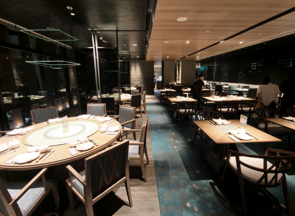 邵中餐廳大廳用餐區黑石牆面與水波意象藍綠地毯