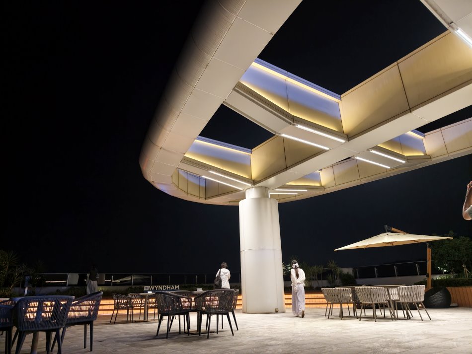 夜間空中花園鋼構間接線燈光影與藤編桌椅休憩區