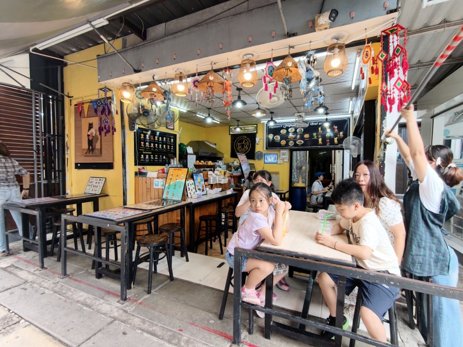 緊鄰鐵軌第一排有遮陽棚的飲品小吃店座位