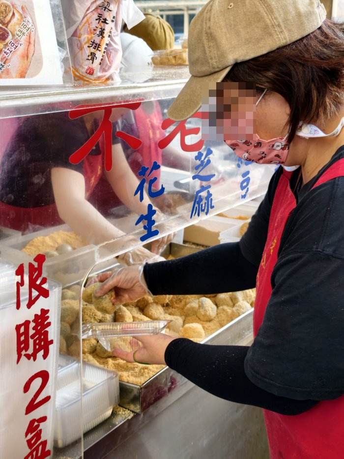 店員熟練將剛裹好花生粉的現做麻糬裝入透明盒
