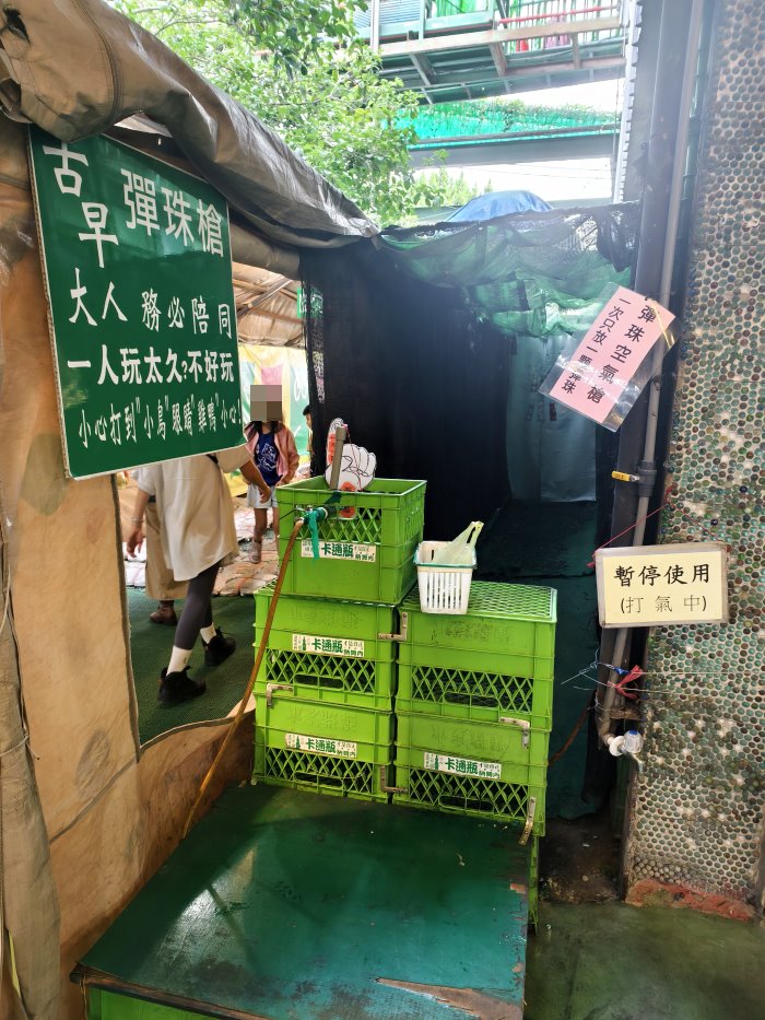 古早彈珠空氣槍體驗區帳篷入口與幽默警示看板