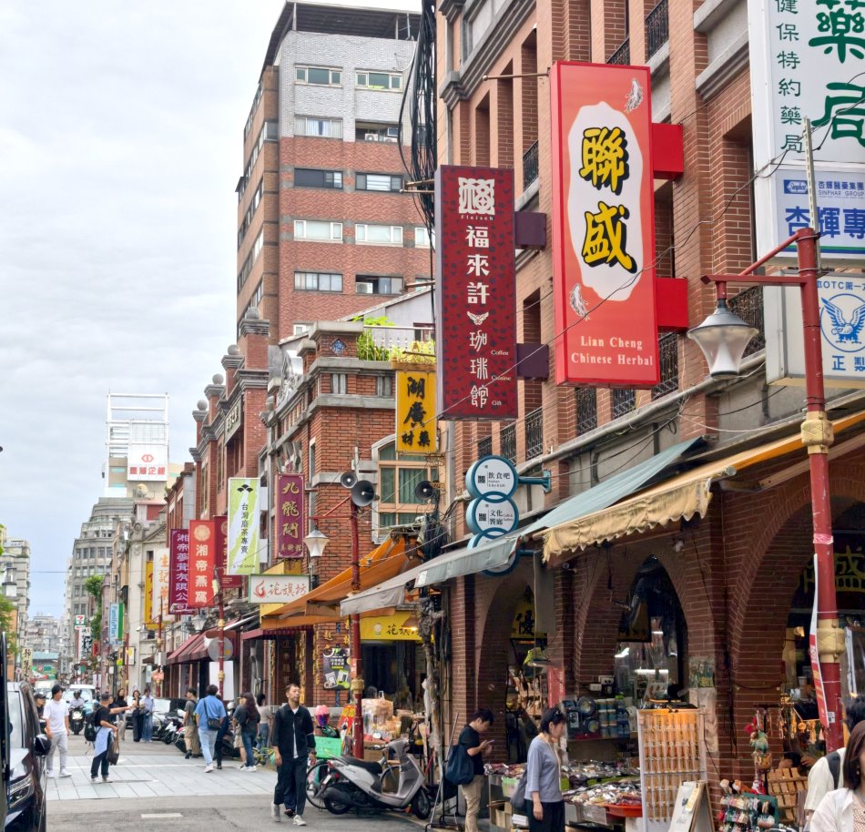 大稻埕迪化街歷史老街街景，紅磚拱形騎樓與中藥乾貨老店