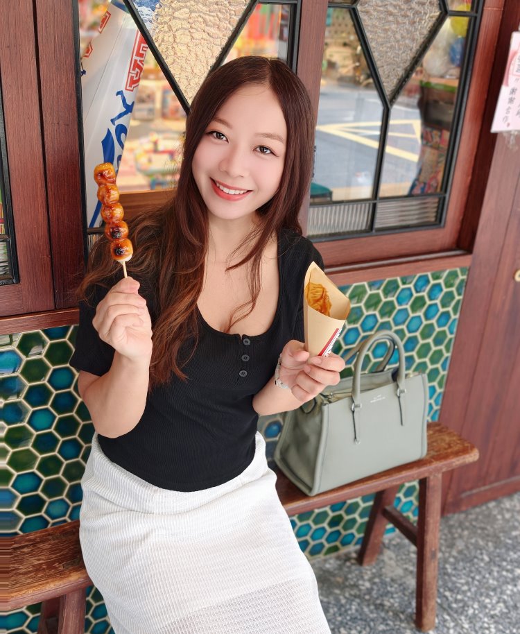 開心中手拿日式烤糰子特寫微笑，赤峰街老屋前悠閒品嚐甜點