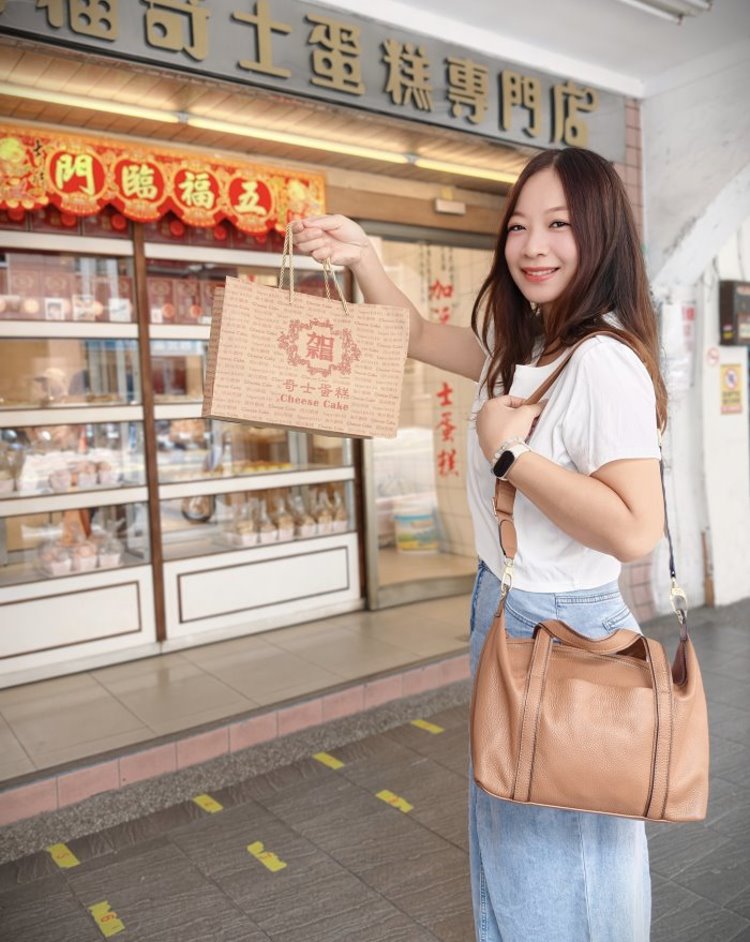 在加福奇士蛋糕專門店門口手提外帶伴手禮紙袋合影