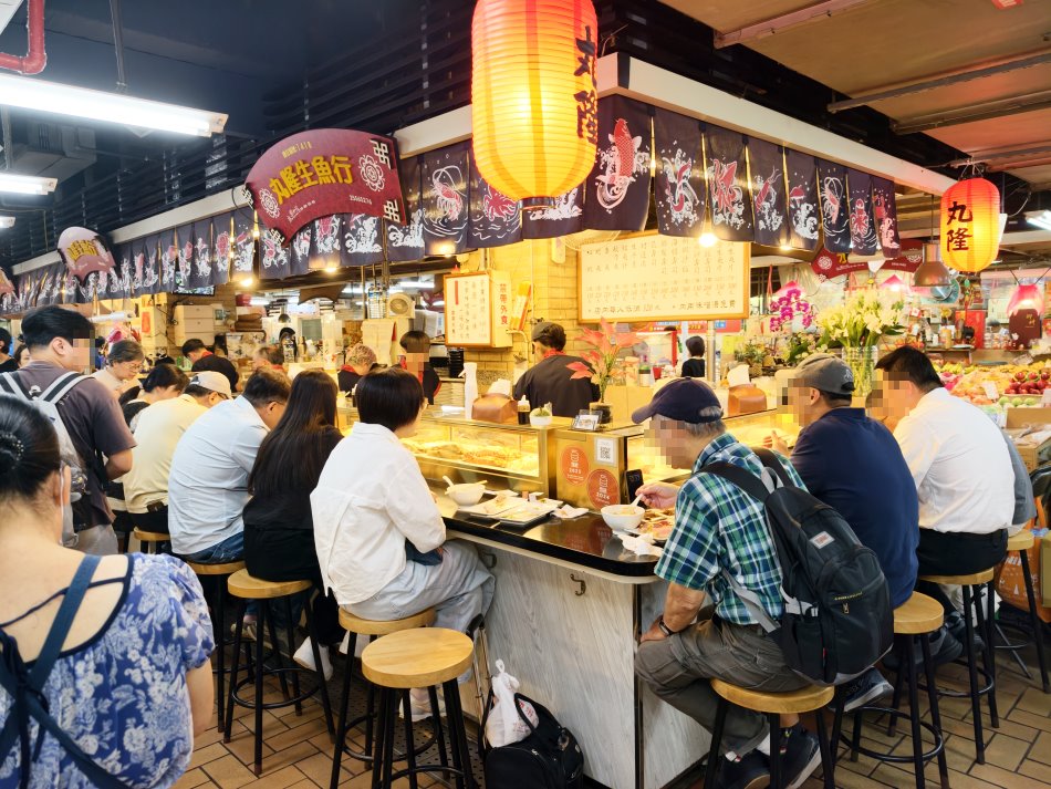 坐在丸隆生魚行板前吧台享用日料與味噌湯的饕客